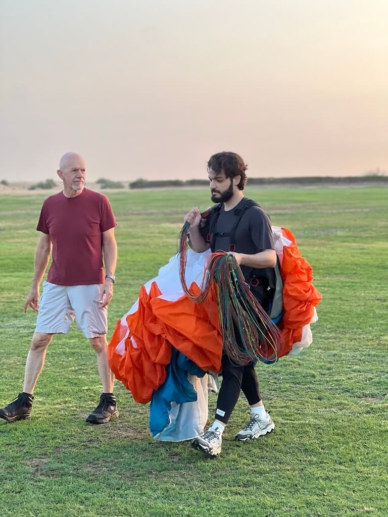 Walking with my instructor, carrying my mushroom wing. Salam Waddah carrying paramotor wing